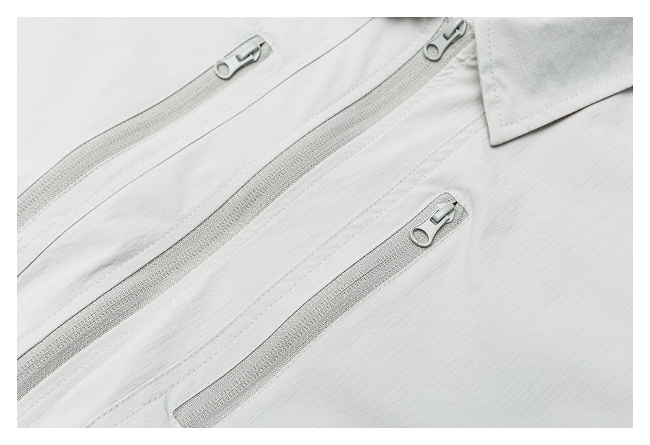 Close-up of three pale gray jacket zippers and part of the pointed collar.