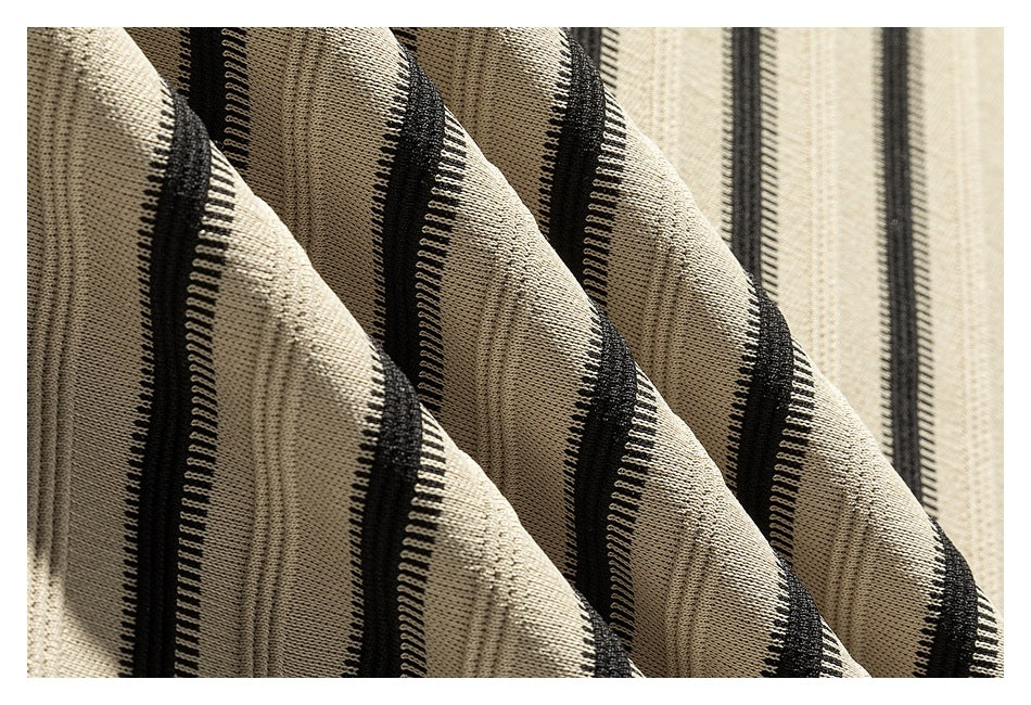 Close-up of beige fabric with raised black vertical stripes and a visible textured weave.