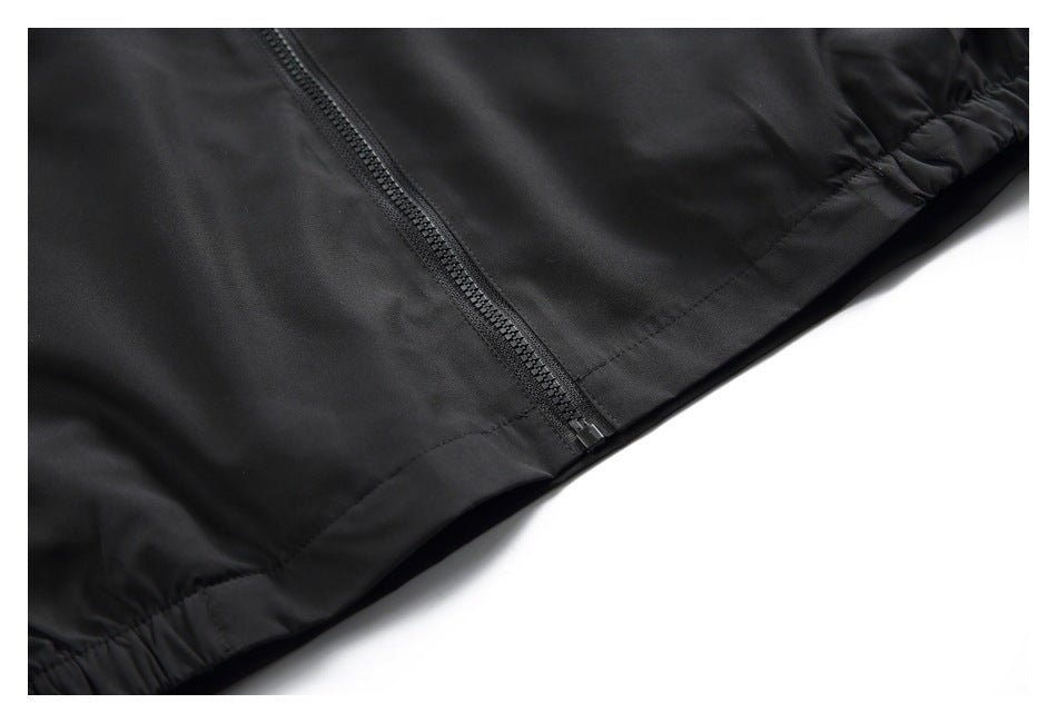Close-up of the black jacket's front zipper and gathered elastic hem.