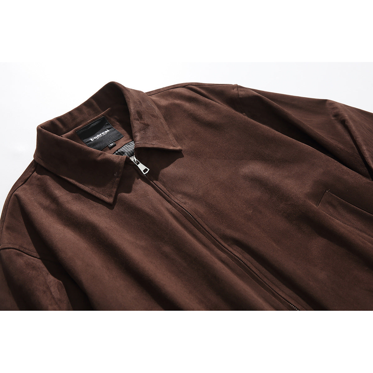 Close-up of a dark brown jacket showing its pointed collar, front zipper, and inner neck label.