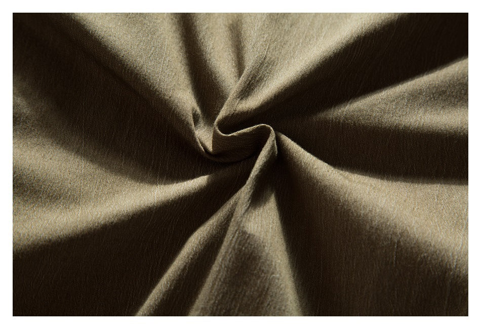 Macro view of olive-brown fabric gathered into folds, showing its fine surface texture.