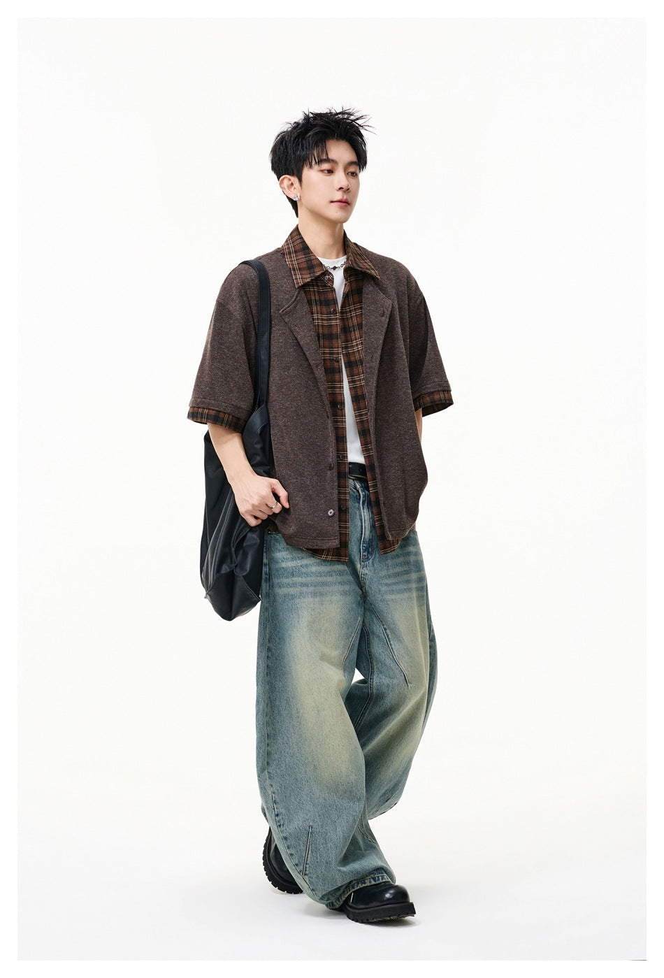 Full-length model wearing an open brown short-sleeve lapel jacket over a plaid shirt and wide-leg jeans.