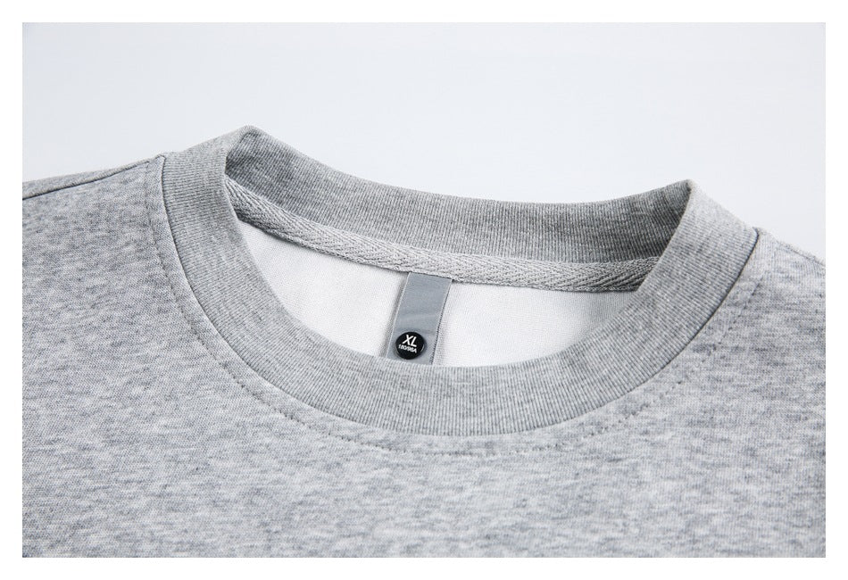 Close-up of a gray tee's ribbed crew neckline and interior size tag marked XL.