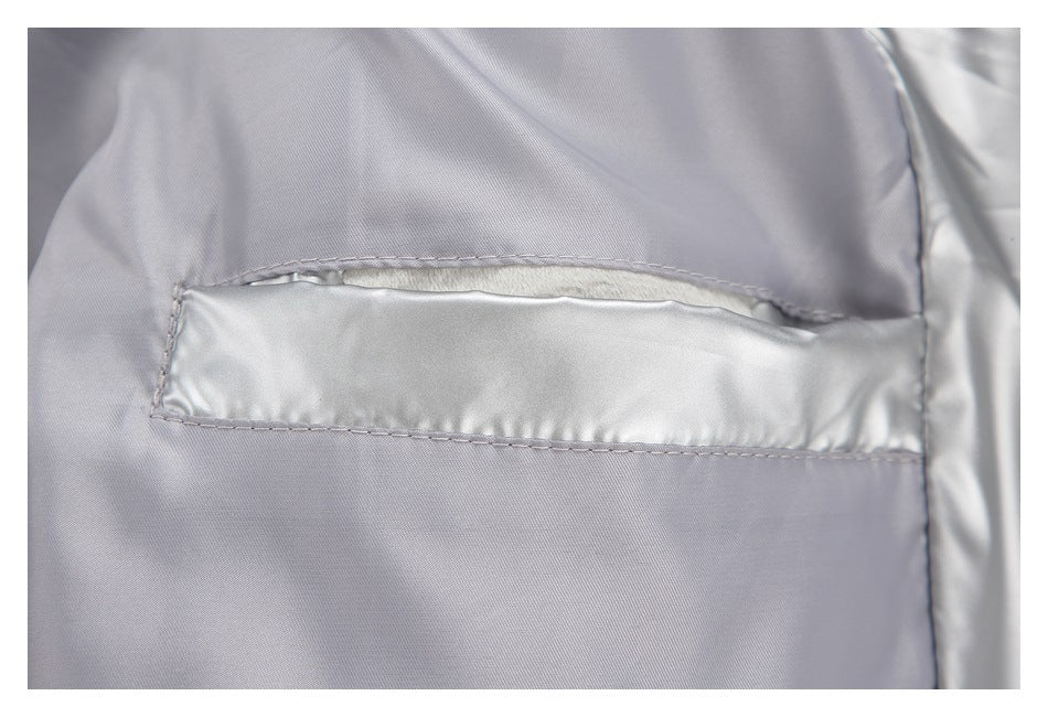 Close-up of a horizontal pocket opening and stitched seams on shiny silver outerwear.