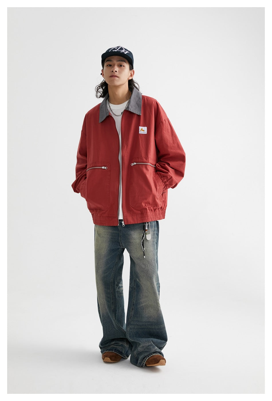 Full-length model wearing a red zip jacket with a gray collar and front pockets.