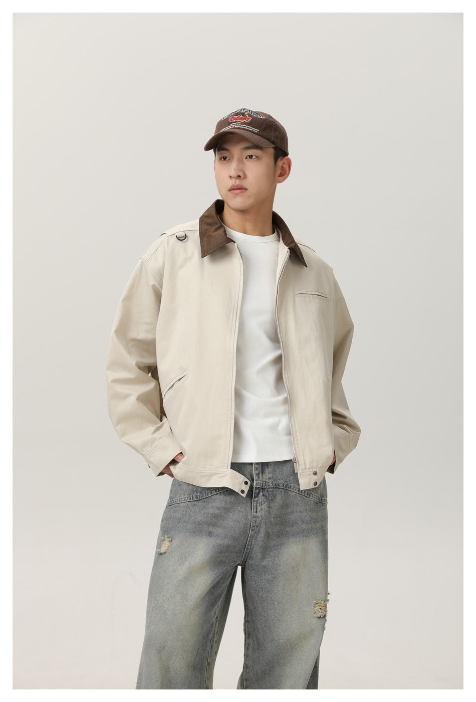 Mid-length front view showing a cream jacket with brown collar, zip closure, chest pocket, and angled pockets.