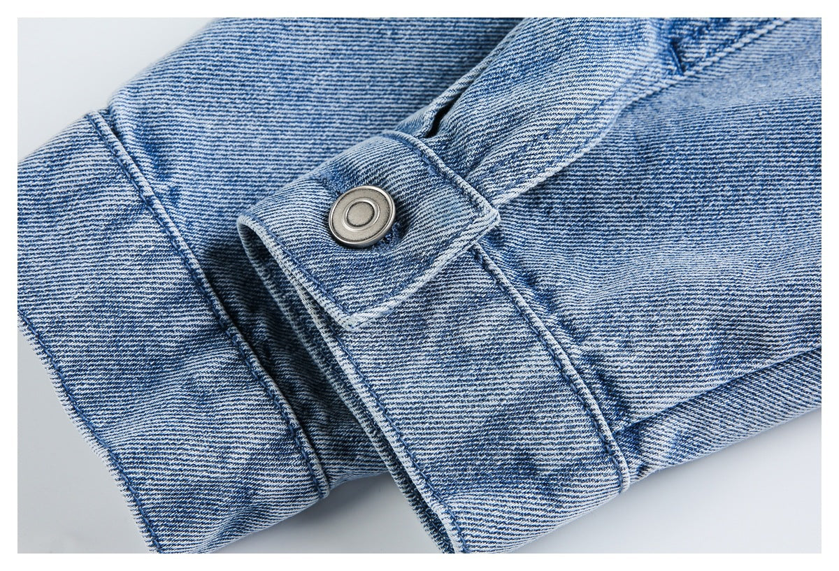 Close-up of a denim cuff strap with a round metal snap and double-stitched seams.