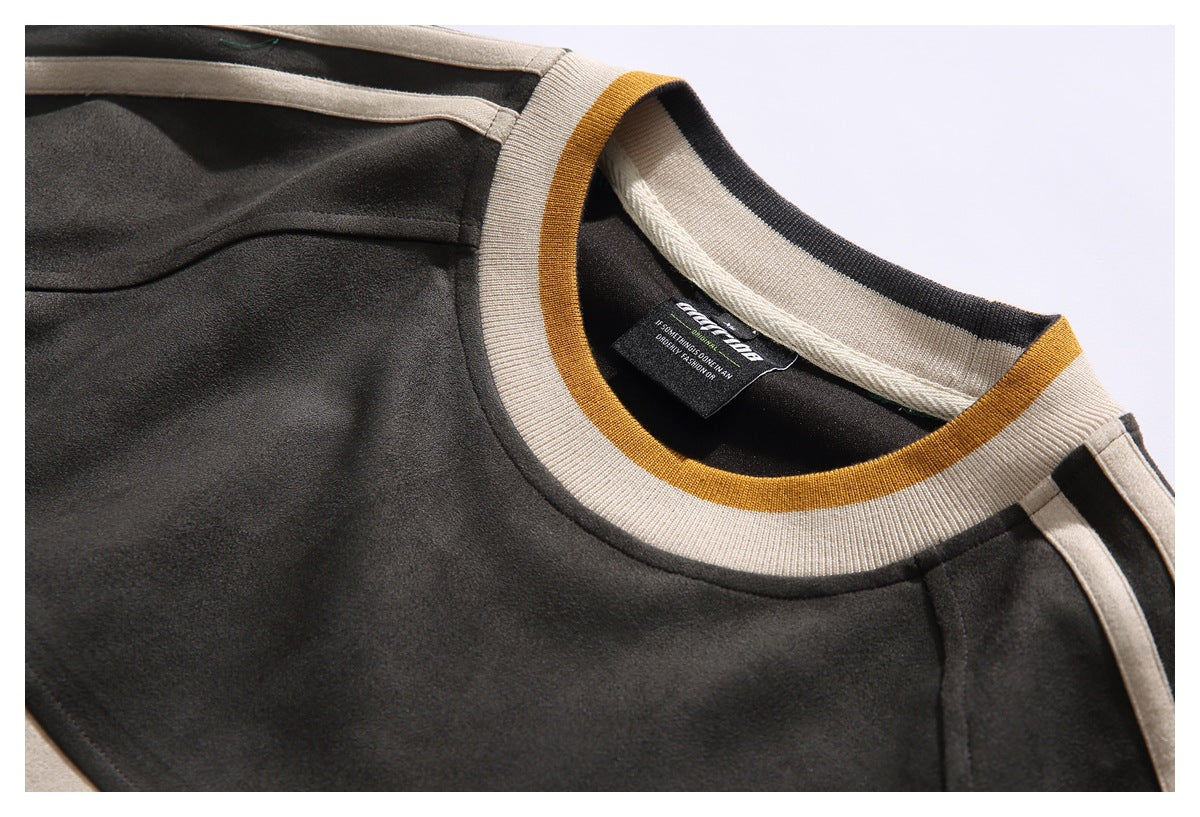 Close-up of a charcoal garment's cream ribbed crew neckline with mustard trim and shoulder stripes.