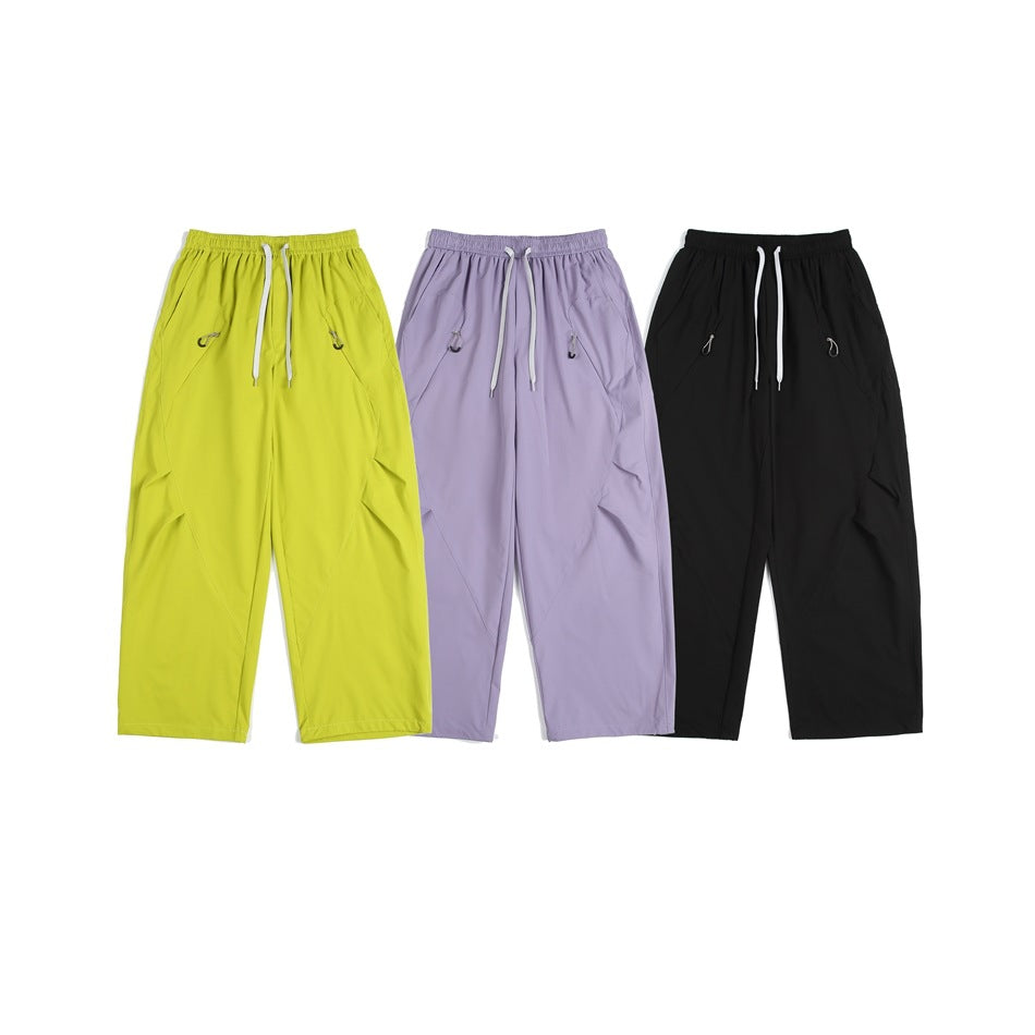 Three pairs of loose drawstring pants shown flat in lime green, lavender, and black.