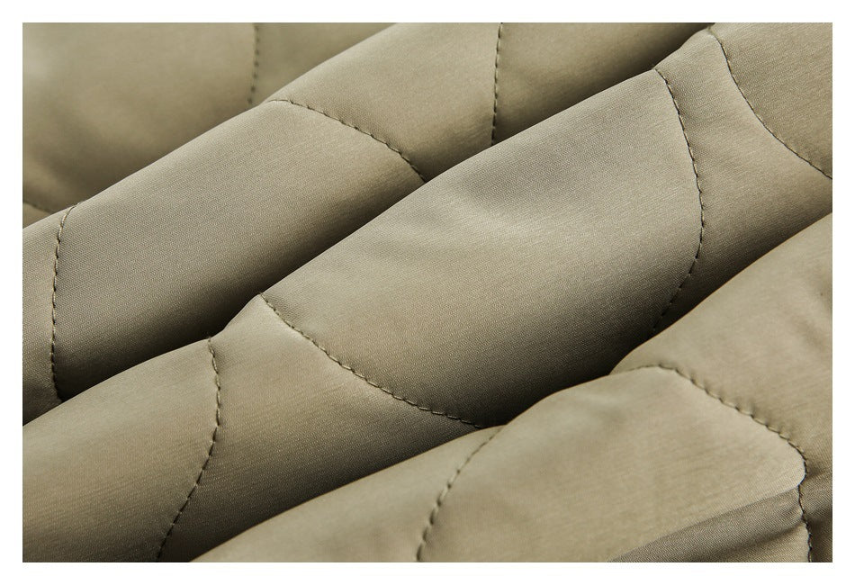 Extreme close-up of olive-khaki fabric and curved quilted seam stitching.