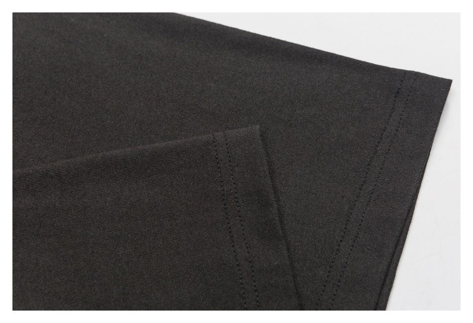 Close-up of a black garment sleeve and hem with visible double stitching.