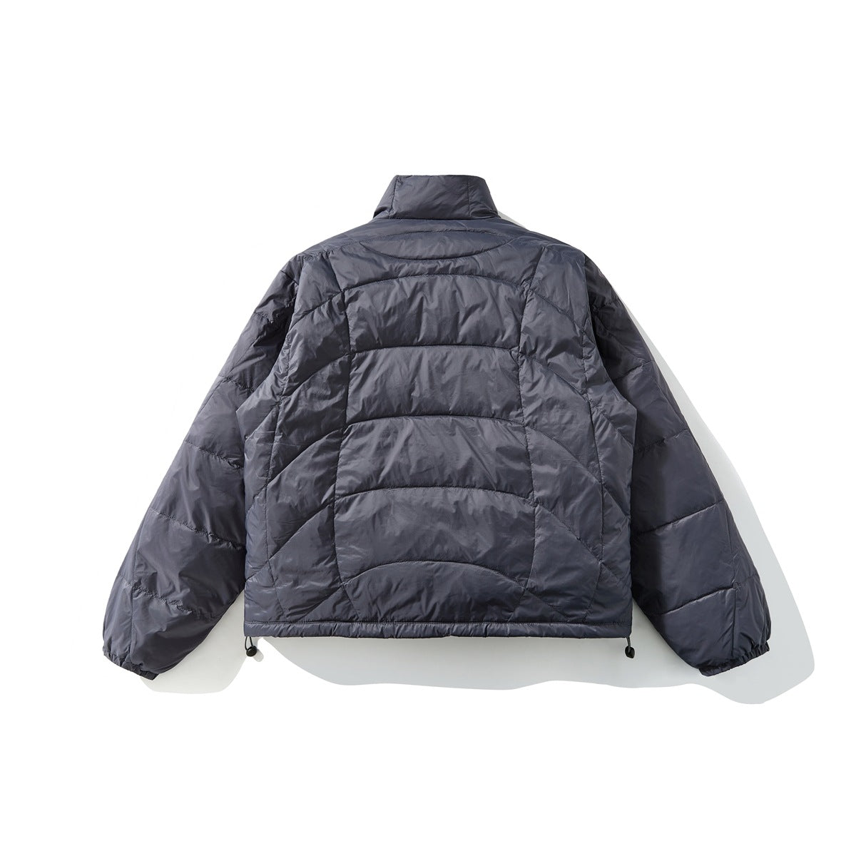 Back view of a dark charcoal quilted jacket with a high collar, curved panel stitching, and adjustable hem cords.