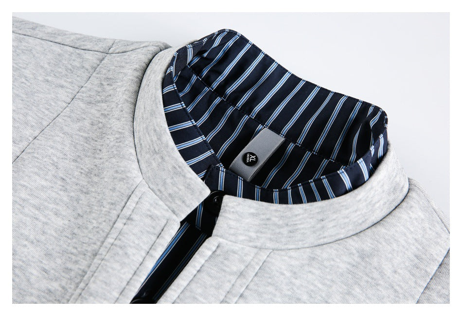 Close-up of a light gray garment collar with navy blue and white striped lining, a black button, and an XL size tag.