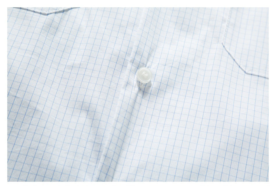 Close-up of a white shirt with a light blue grid pattern, showing a white button and stitched placket.