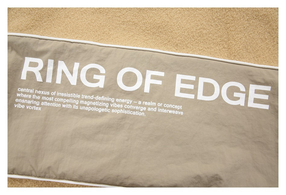 Close-up of taupe fabric with white piping and large white “RING OF EDGE” text.