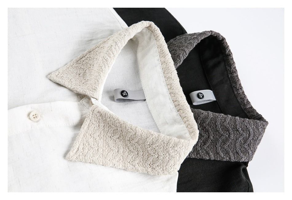 Close-up of white and black shirt collars with contrasting textured fabric and small neck labels.