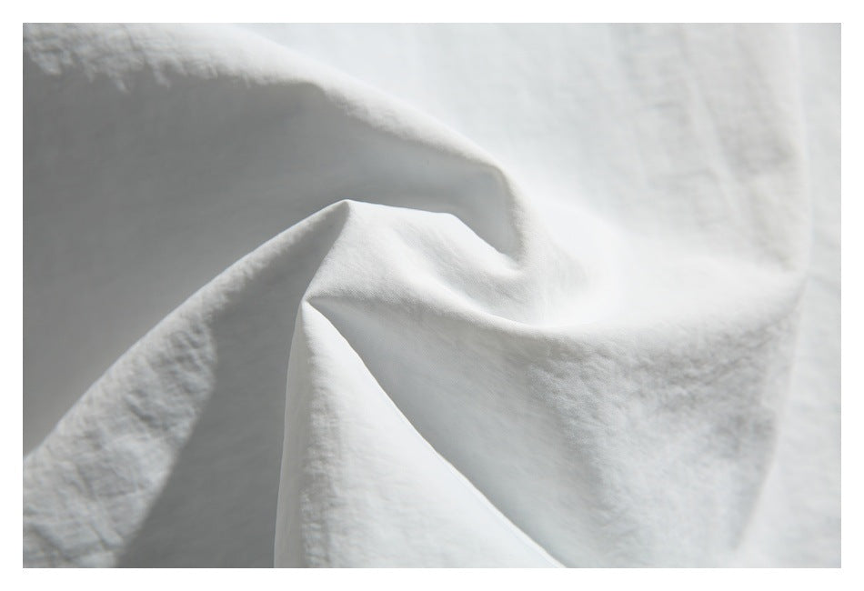 Close-up of softly folded white shirt fabric.