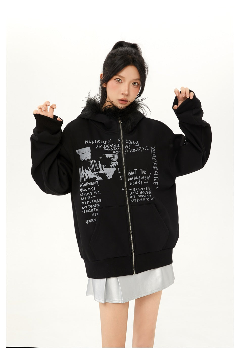 Model in a black zip hoodie with fur-like hood trim and silver-gray text print, close three-quarter view