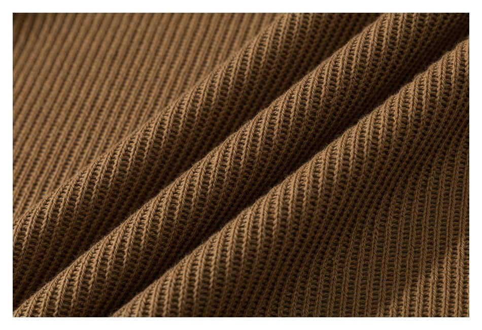 Close-up of brown ribbed knit fabric arranged in soft folds.