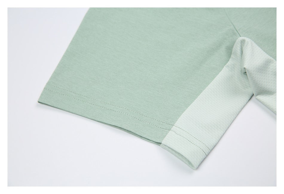 Close-up of a mint green shirt sleeve hem beside a pale textured contrast panel.
