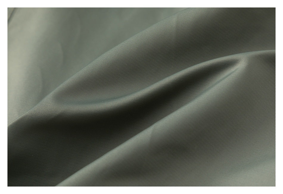 Close-up of olive-gray fabric draped to show its fine surface texture and folds.