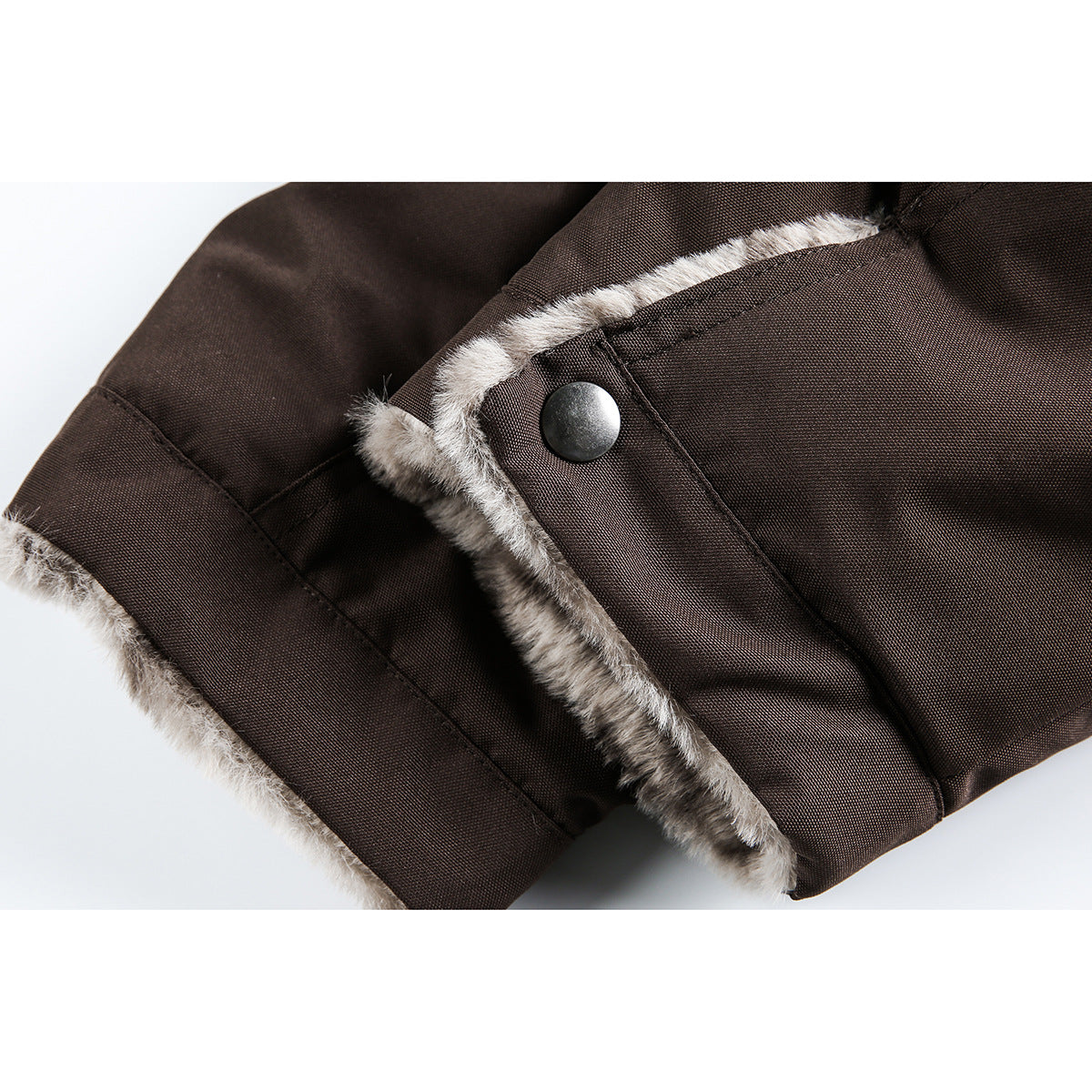 Close-up of a brown jacket cuff and snap tab, edged with gray plush lining.