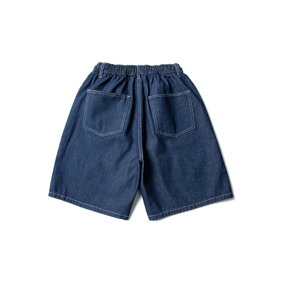 Back view of dark blue denim shorts with two patch pockets, elastic waistband and contrast topstitching