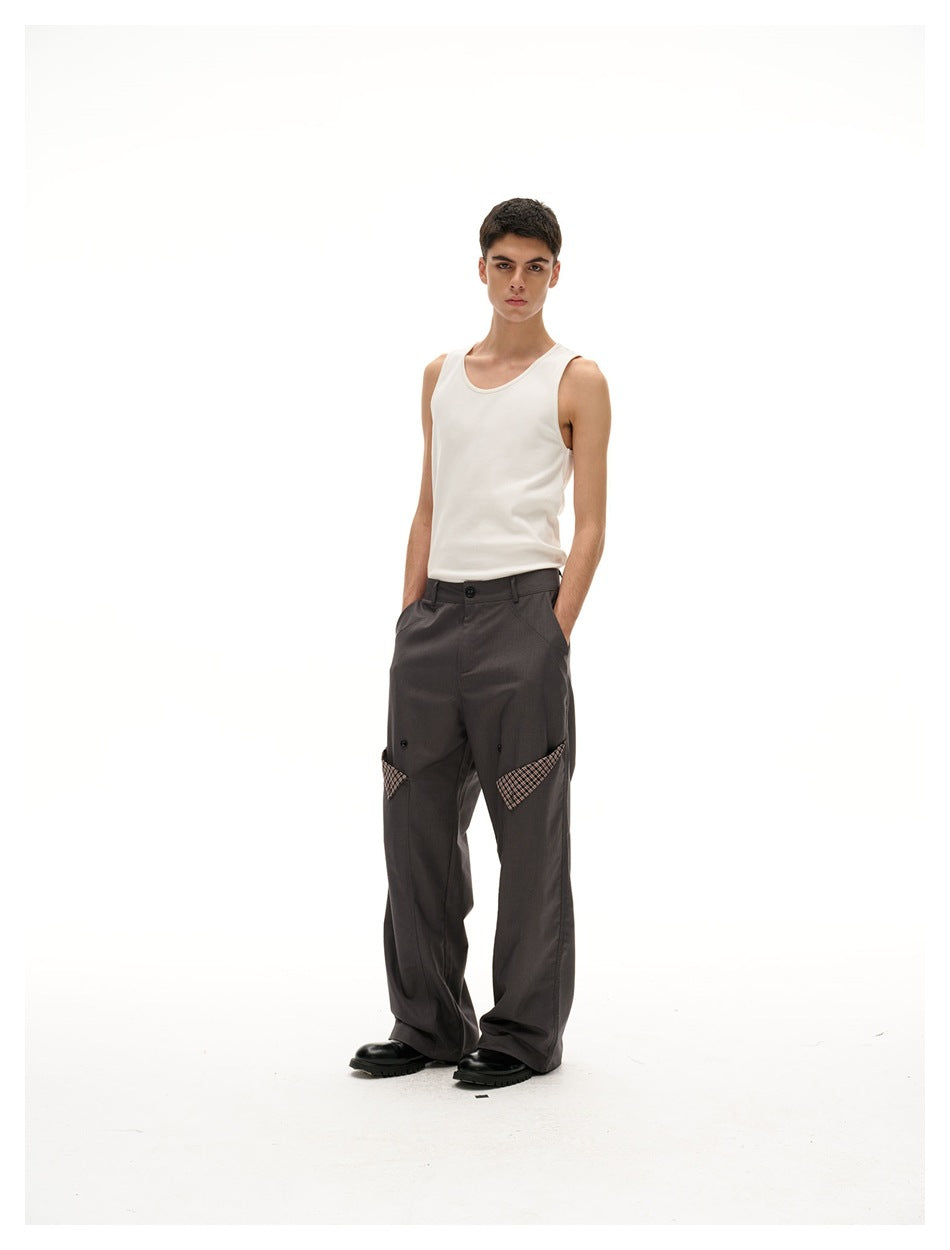 Full-length front view of a model wearing a cream tank top and charcoal wide-leg trousers with plaid pocket accents.