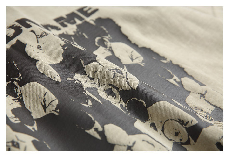 Close-up of a beige garment with a large black illustrated print and partial lettering.