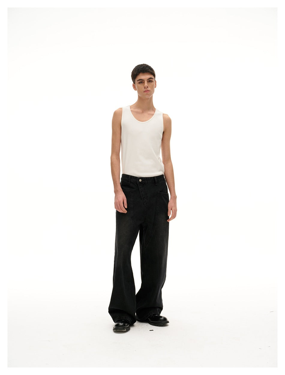Front-facing model wearing a white sleeveless tank top and wide black jeans against a white studio backdrop.