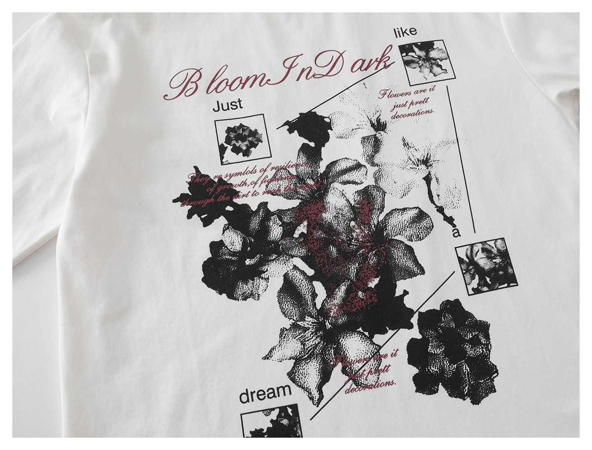 Close-up of a white T-shirt with a black and burgundy floral graphic and English lettering.