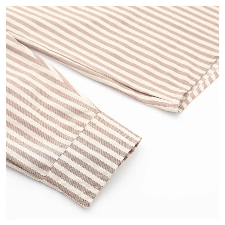 Close-up of the beige-and-white striped shirt sleeve and button cuff.