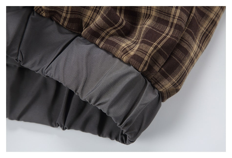 Close-up of a brown plaid sleeve meeting a gathered gray cuff.