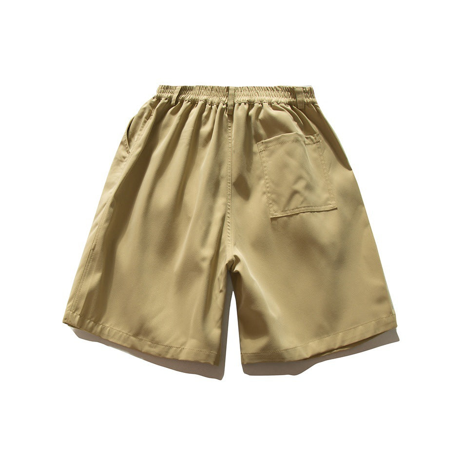 Back view of tan shorts with an elastic waistband and a rectangular patch pocket.