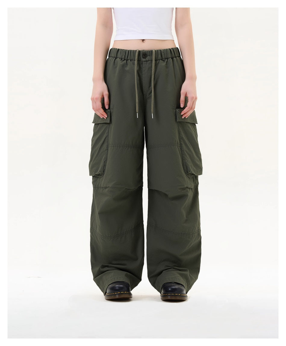 Person wearing green wide-leg cargo pants with drawstring elastic waist, white crop top and black boots