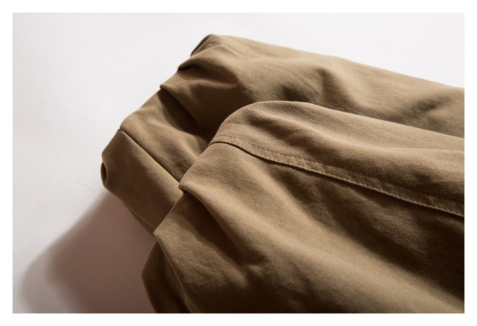 Close-up of folded tan-brown garment fabric with a stitched seam.