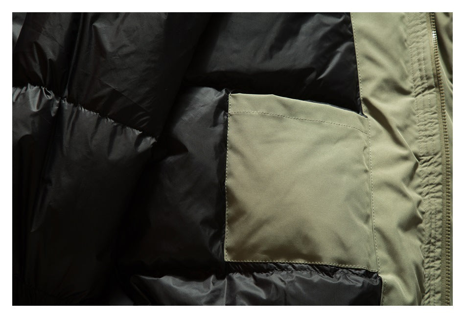 Close-up of a rectangular olive-green interior pocket against black quilted jacket lining, beside the zipper.