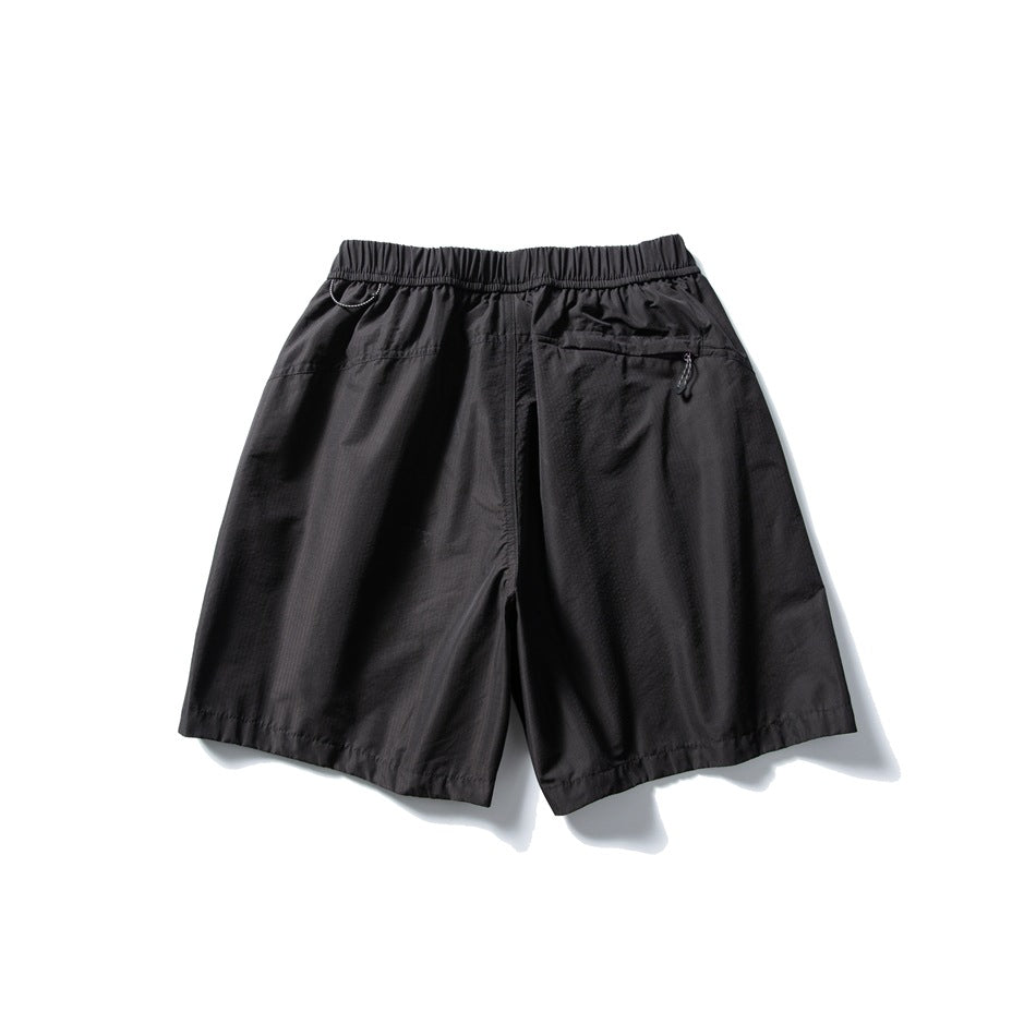 Black shorts shown from the back, with an elastic waistband and a zippered rear pocket.