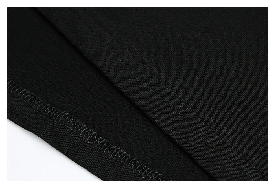 Close-up of black garment fabric showing a stitched seam and overlocked edge.