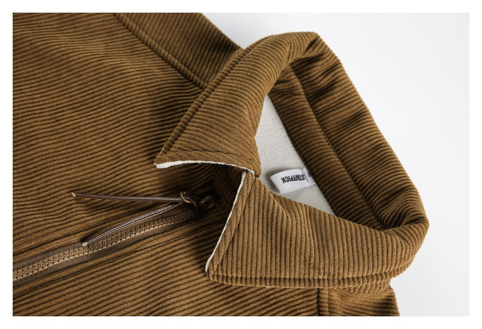 Close-up of a camel-brown ribbed jacket collar, white lining, and front zipper; a small fabric label is visible inside.