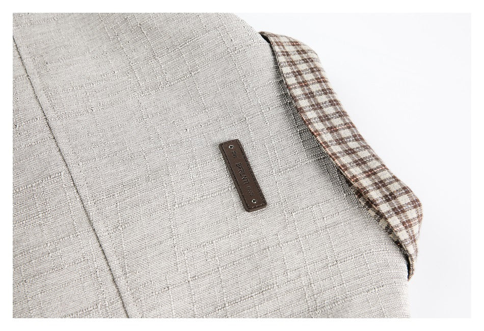 Close-up of light beige textured fabric, brown plaid edging, and a small sewn-on brand label.