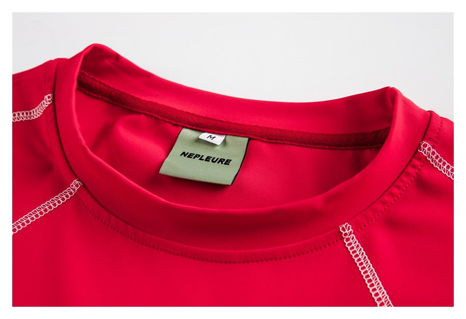 Close-up of a bright red shirt’s crew neckline, white contrast stitching and sewn-in NEPLEURE size M label.