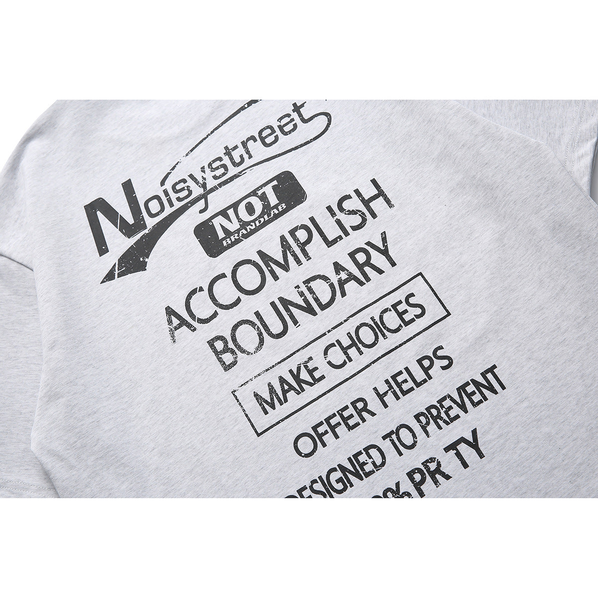 Close-up of a light gray heather T-shirt with a large distressed black text graphic on the front.
