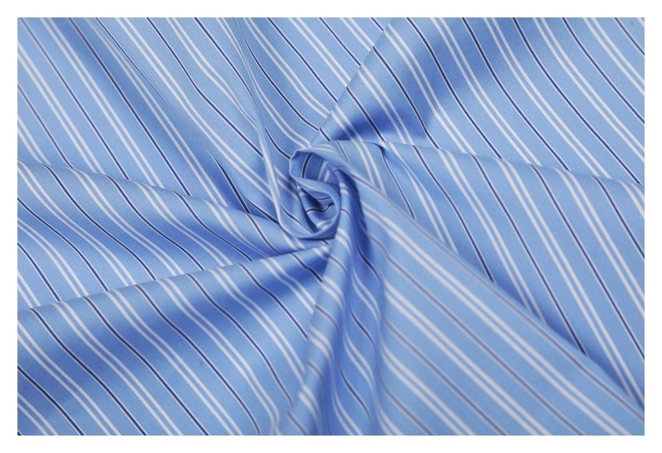 Close-up of the blue striped fabric gathered into a spiral to show its drape.