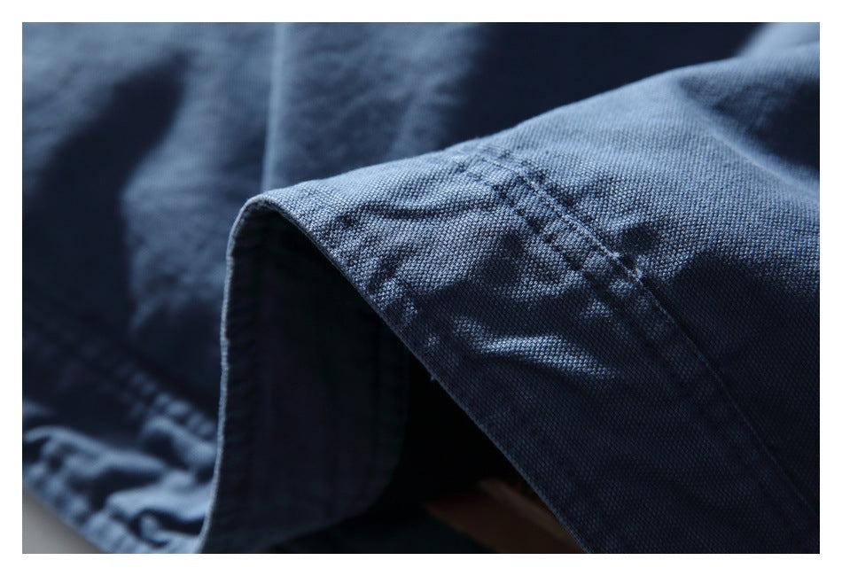 Close-up of dark blue denim fabric showing a folded edge and stitched seam.