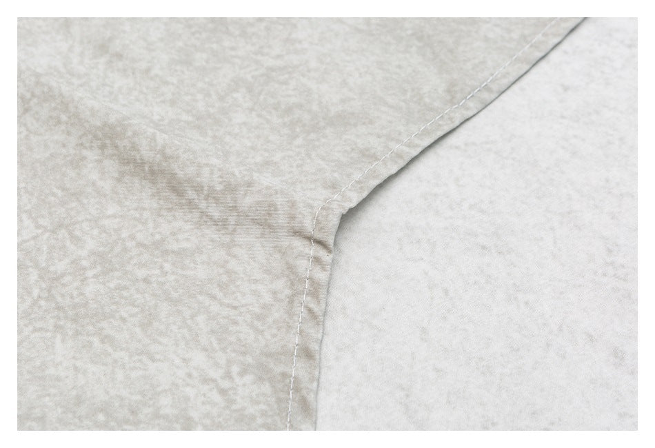 Close-up of a curved stitched seam on light beige mottled fabric.