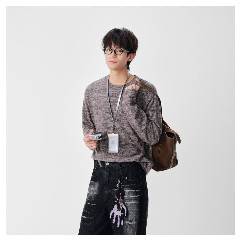 Model wearing a mottled taupe-gray crewneck sweater with long sleeves; shown from head to hips.