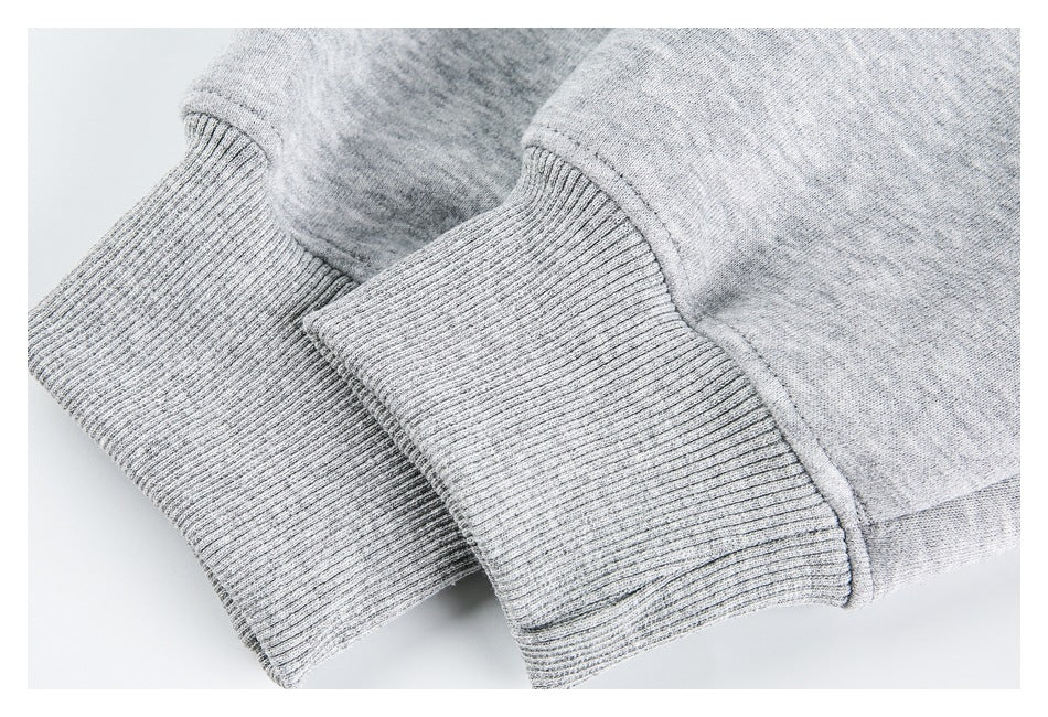 Close-up of two ribbed cuffs on a light gray heathered garment.