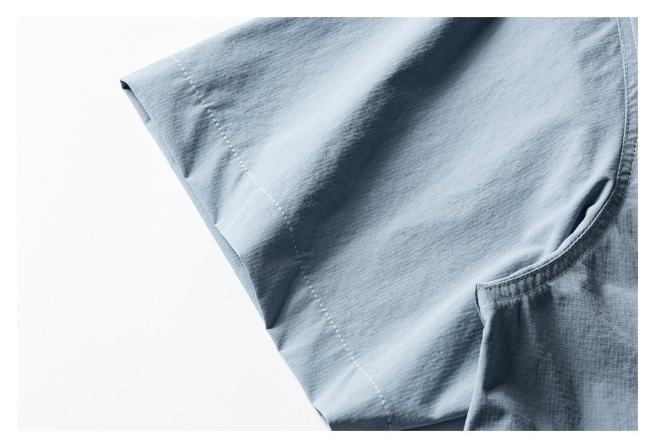 Close-up of a light blue garment sleeve seam and curved pocket opening.