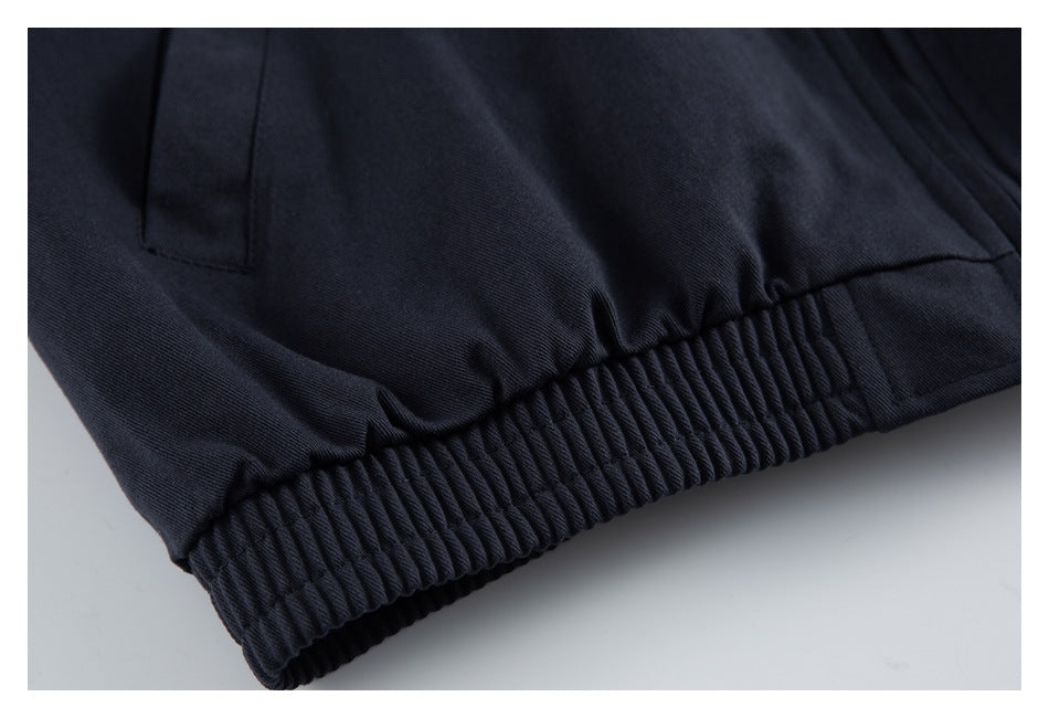 Close-up of a dark navy garment with a gathered elastic hem and a nearby pocket opening.